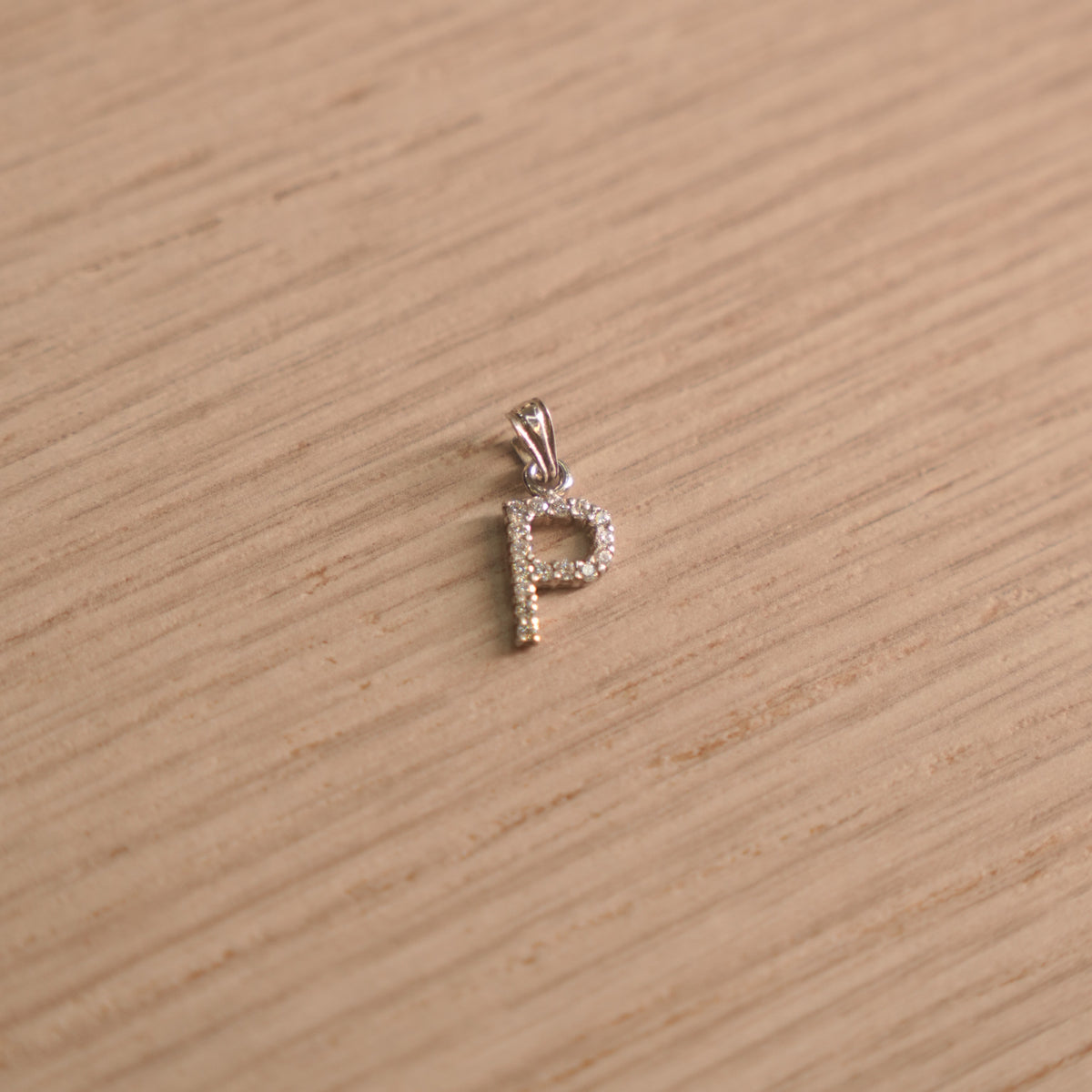 Sterling silver initial P pendant pave set with American Diamond, shown with its bail on a plain background.