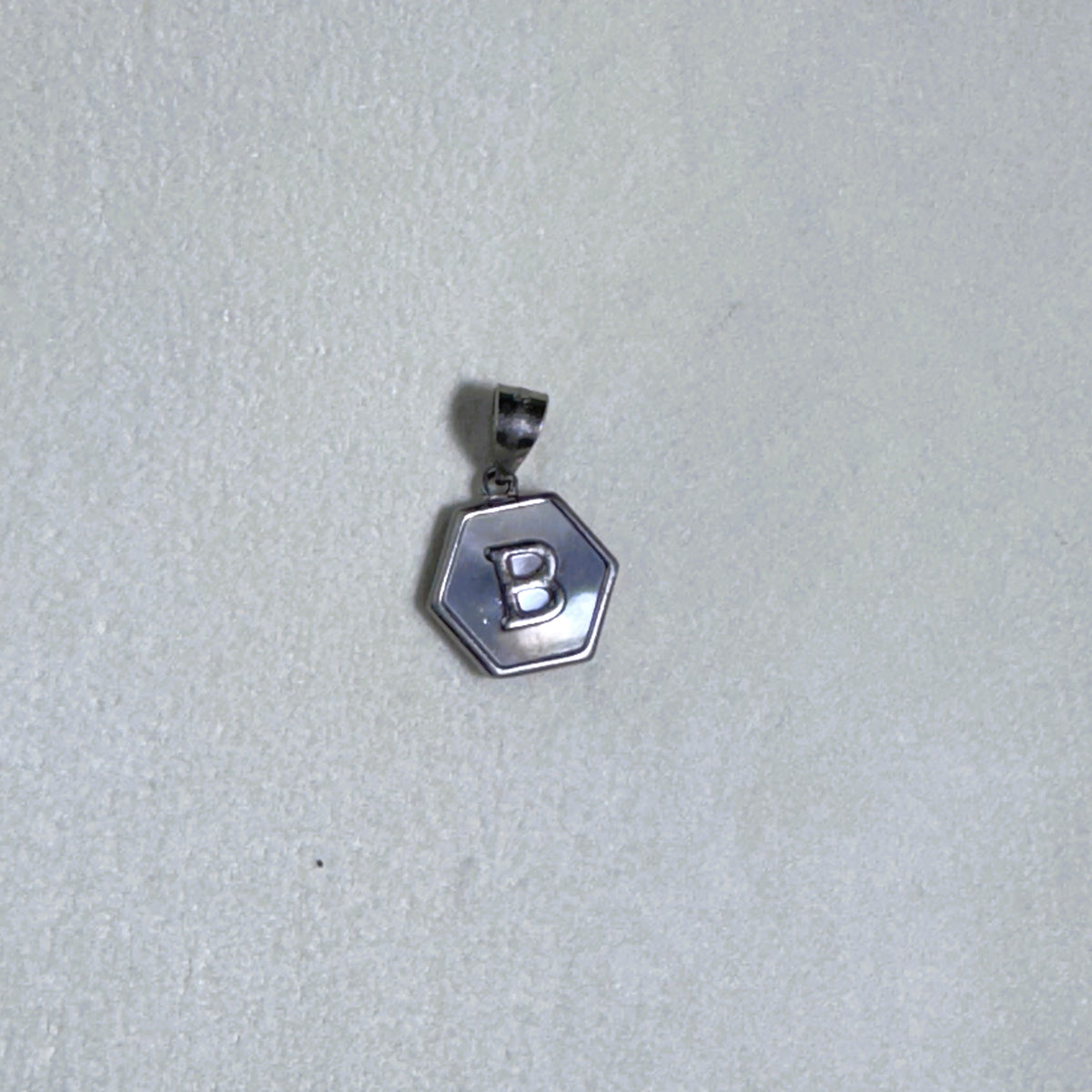 Sterling silver hexagon initial pendant with a mother of pearl face and the letter B.