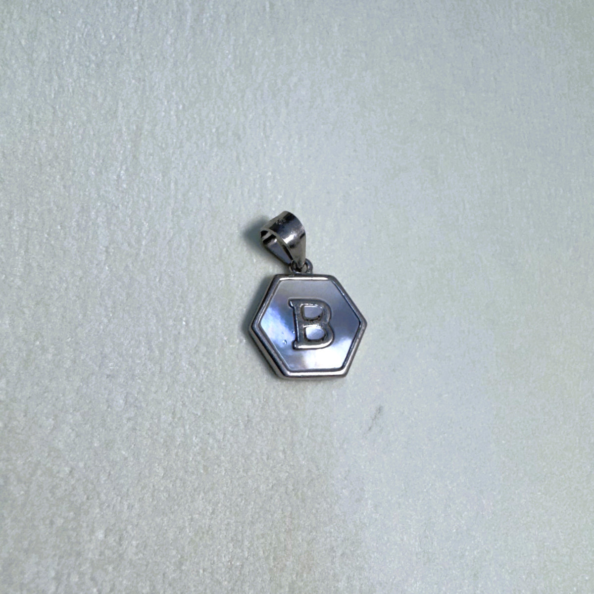 The letter B hexagon pendant seen from a slight angle.
