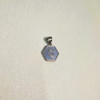 The letter G pendant seen from a slight angle.