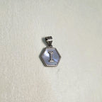 The letter I hexagon pendant on a pale surface.