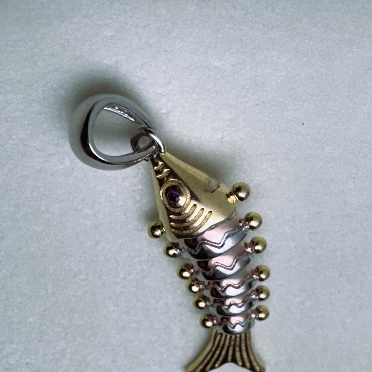 The tri-tone fish pendant with its silver bail, seen from above.