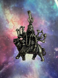 Oxidised sterling silver Goddess Durga pendant seated on her lion, against an iridescent nebula-print backdrop.