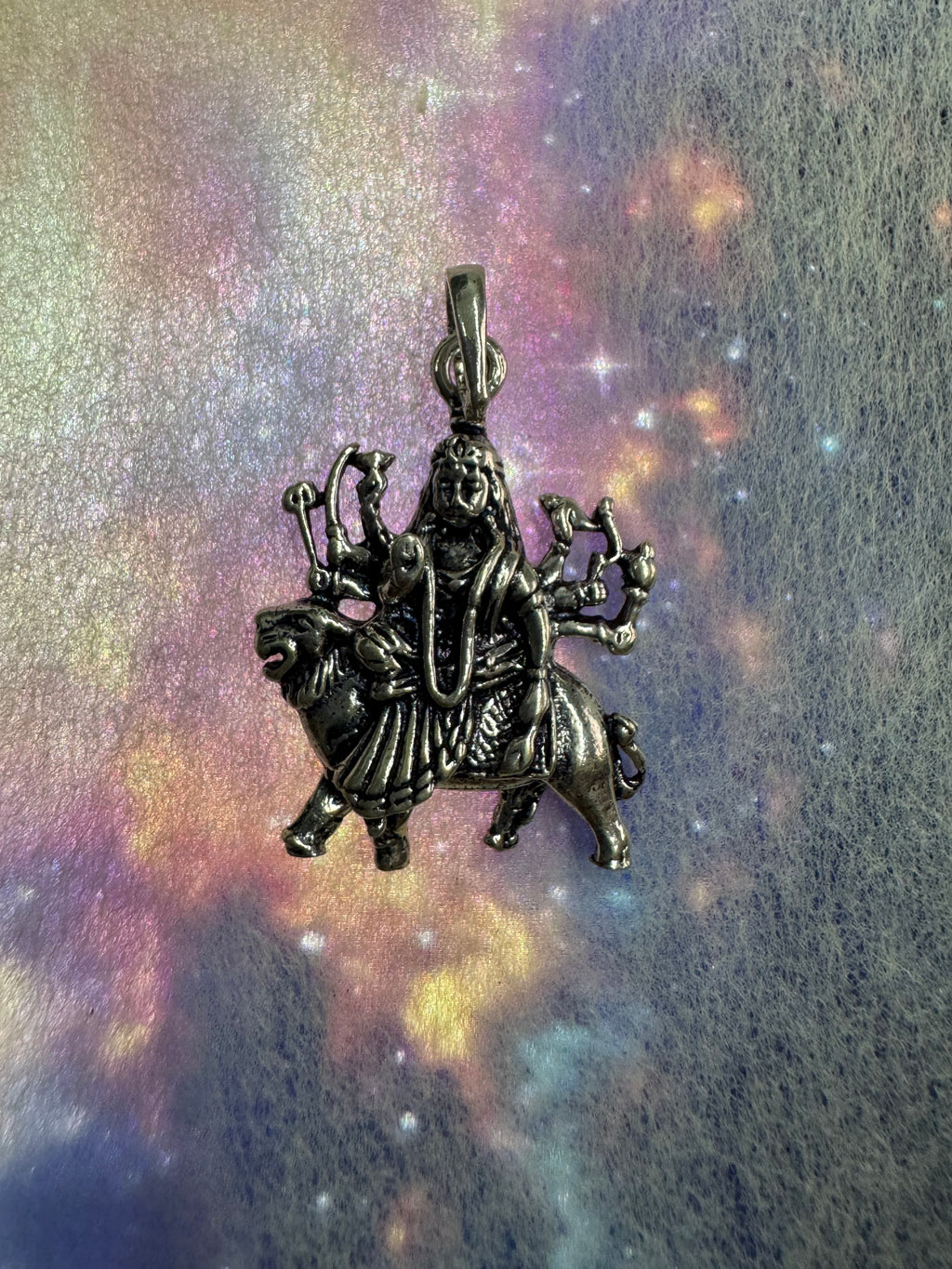 Angled view of the sterling silver Durga pendant, showing the long tapered bail and jump ring.