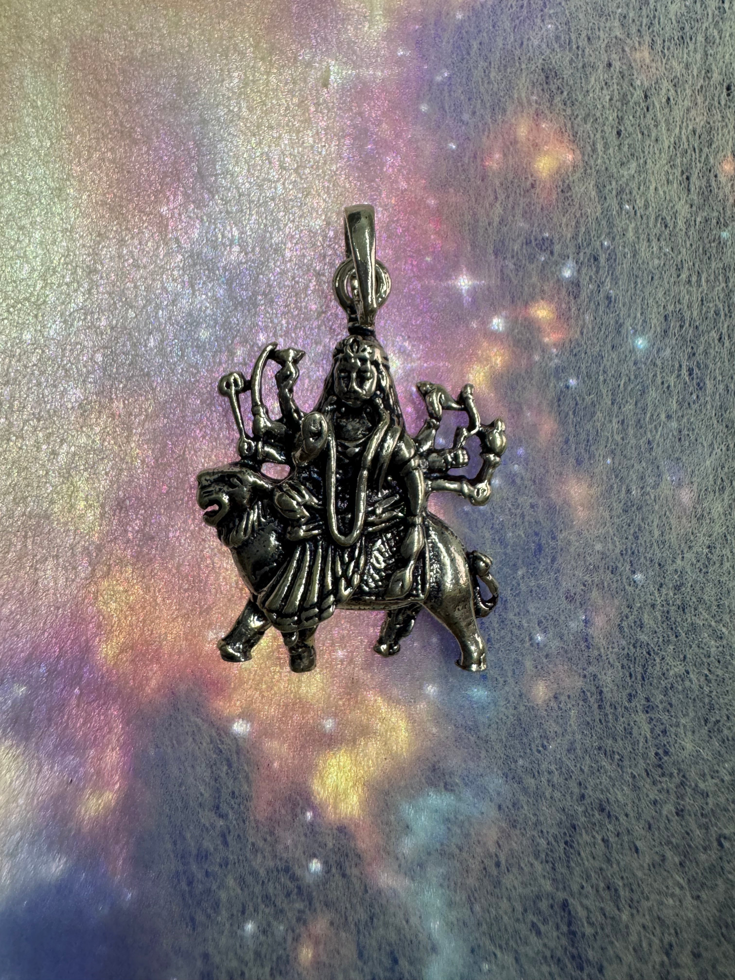 Angled view of the sterling silver Durga pendant, showing the long tapered bail and jump ring.