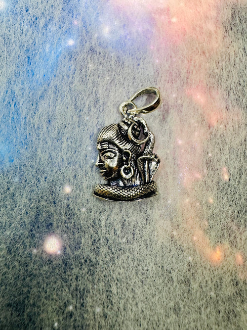 The sterling silver Shiva profile pendant on a grey and pink iridescent backdrop, bail at the top.