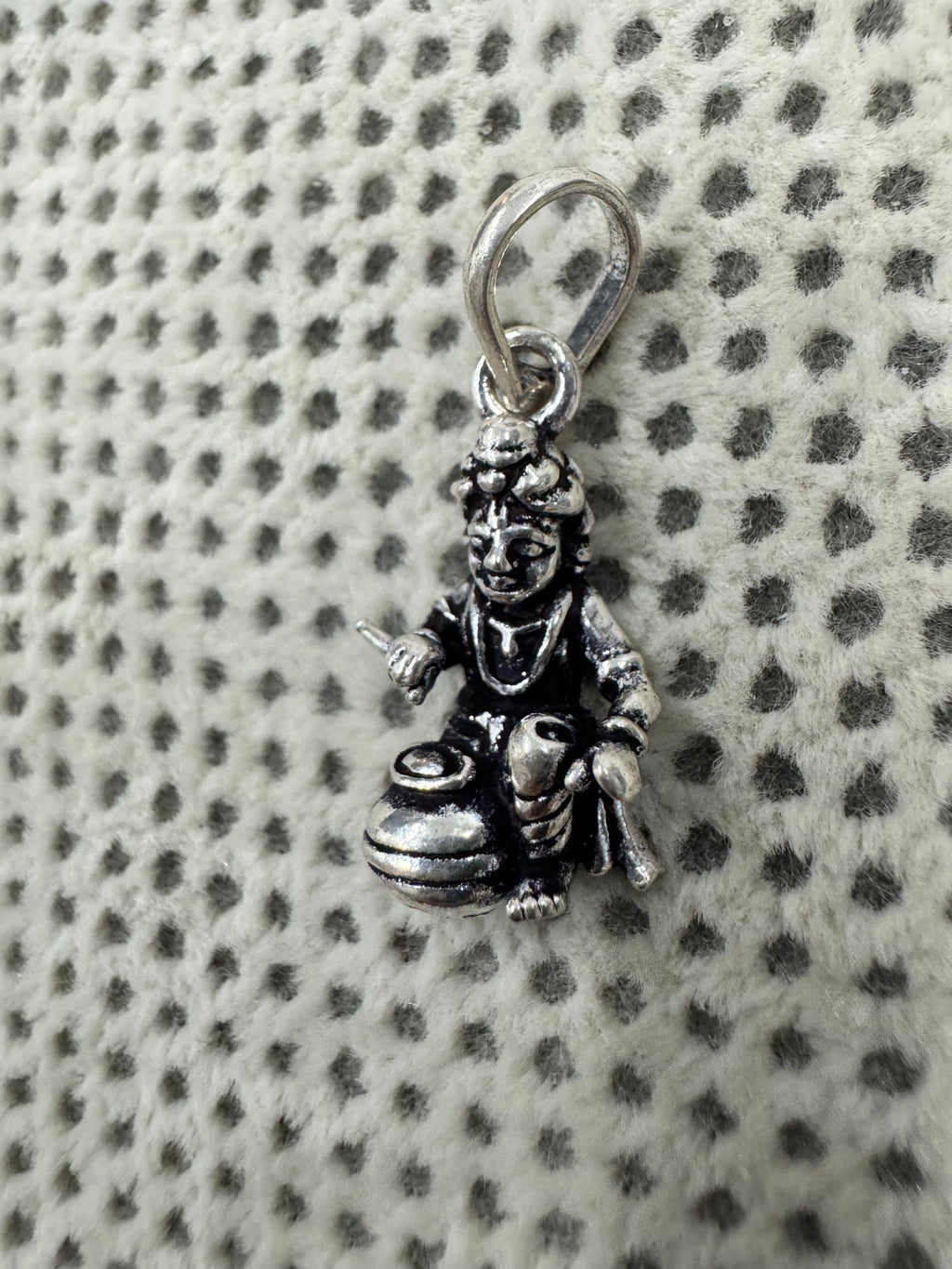 Close view of the crown, face and chest ornament on the sterling silver Bal Gopal pendant.