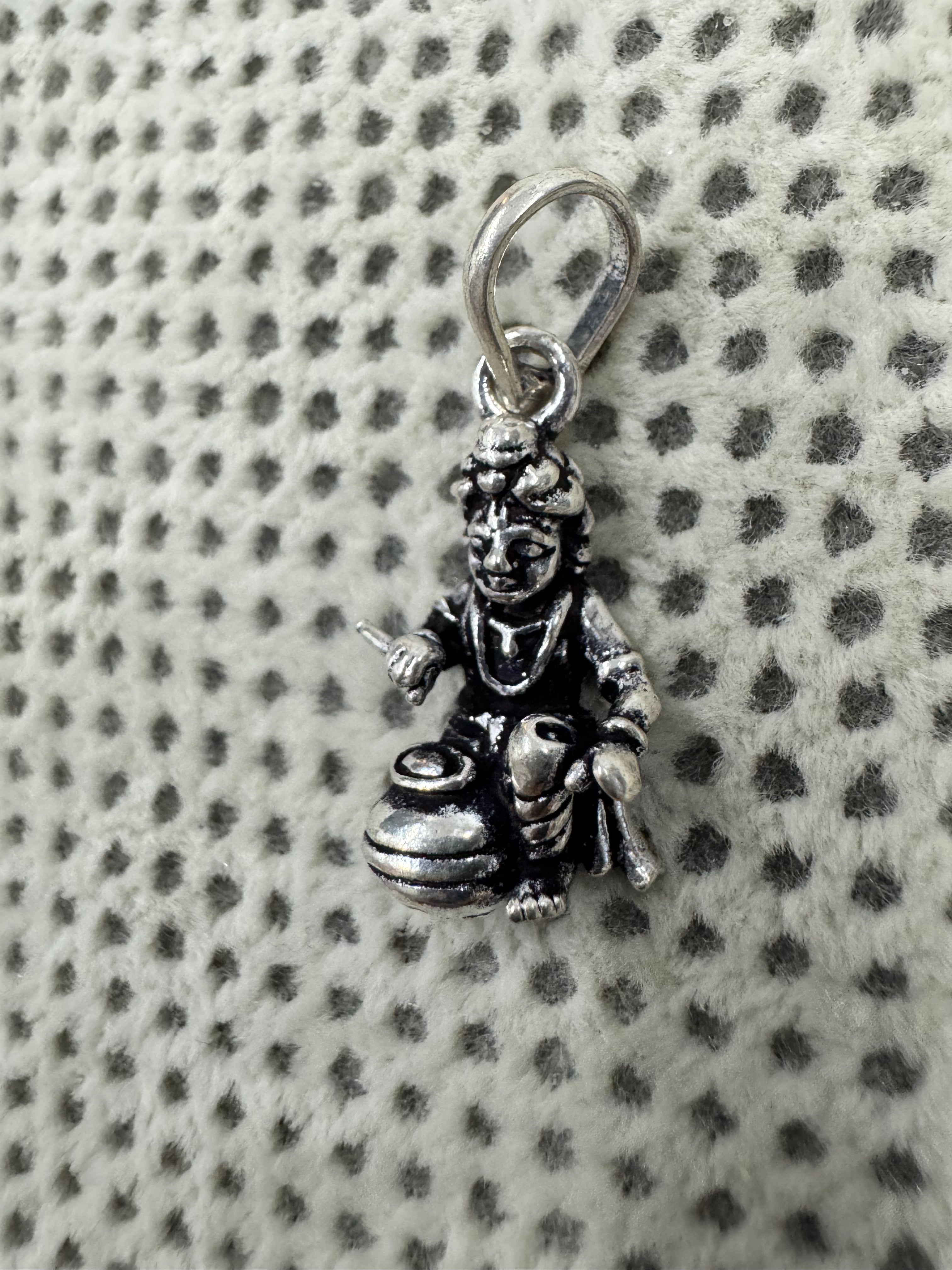 Close view of the crown, face and chest ornament on the sterling silver Bal Gopal pendant.