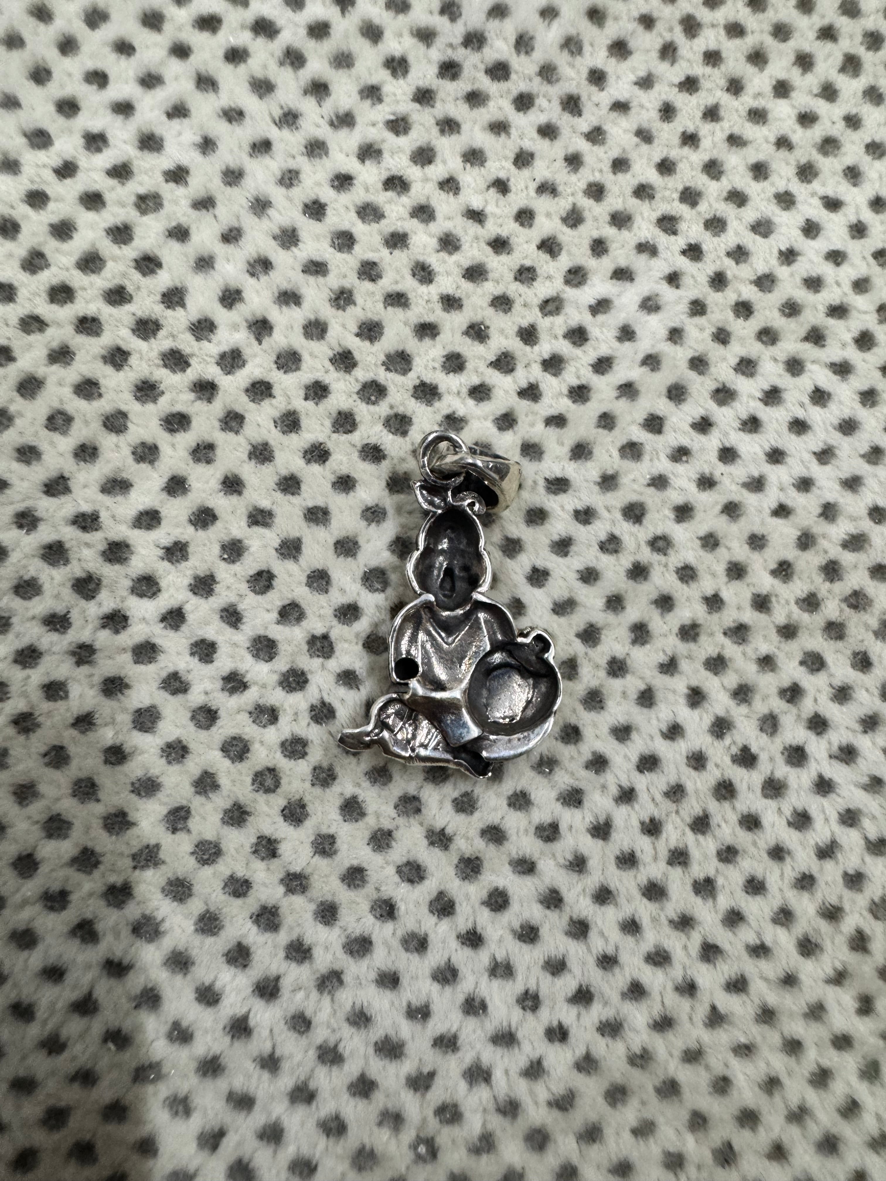 Reverse of the sterling silver pendant, showing the smooth hollow back behind the cast figure.