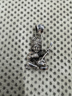 Cast sterling silver pendant showing the crossed legs, a round butter ball in one fist and the flat tapered bail.