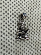 Angled view of the sterling silver pendant, the churning stick set into the mouth of the pot at the figure's lap.