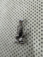 Full length of the sterling silver pendant with its flat tapered bail and jump ring on grey dotted fabric.