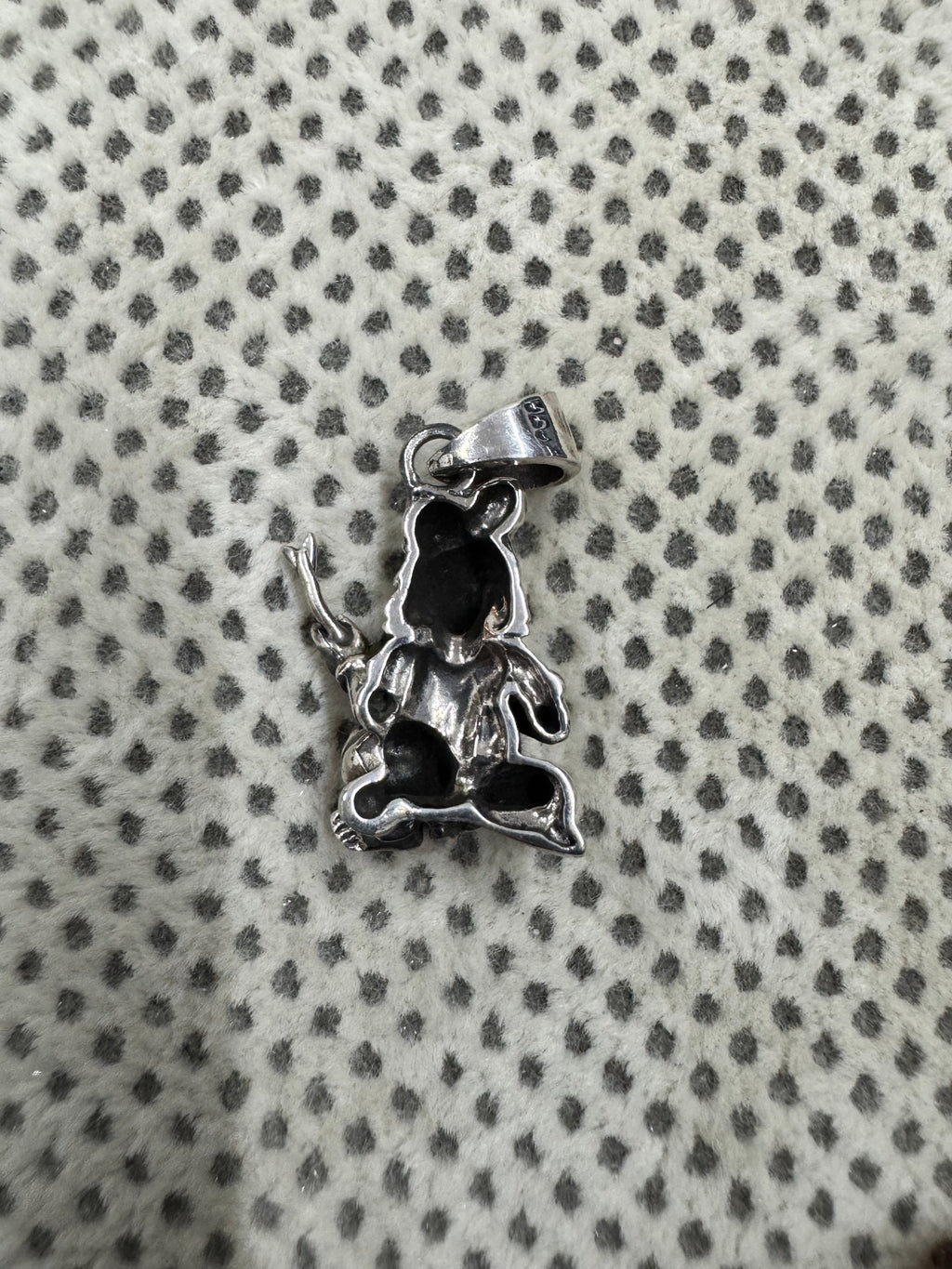 Reverse of the sterling silver pendant, showing the hollow oxidised back and the flat tapered bail.