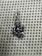 Sterling silver krishan pendant photographed small on dotted fabric to show its proportion beside the bail.