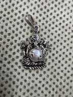 Close view of the pearl in its four cast claws on the sterling silver Ganesha pendant, with the oval bail loop alongside.