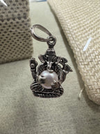 Sterling silver Ganesha pendant with pearl on a grey-green card, a jute weave behind it.