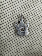 Reverse of the sterling silver Ganesha pendant on dotted fabric, the open back showing the underside of the pearl.