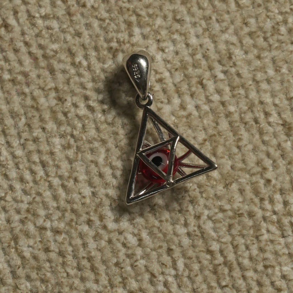 Reverse of the sterling silver triangle Pendant revealing the red-and-white eye bead held within the frame.