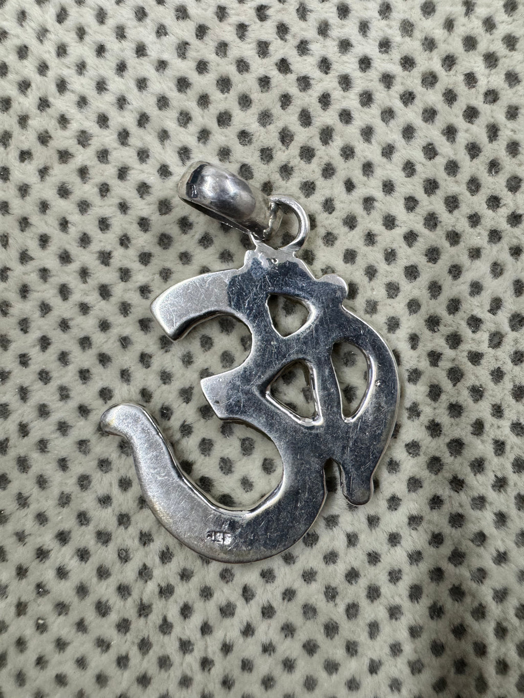 Reverse of the sterling silver Om pendant, showing the flat back and the 925 purity stamp.