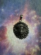 Sterling silver sun disc pendant on a blue and violet iridescent backdrop, the flat bail and jump ring at the rim.