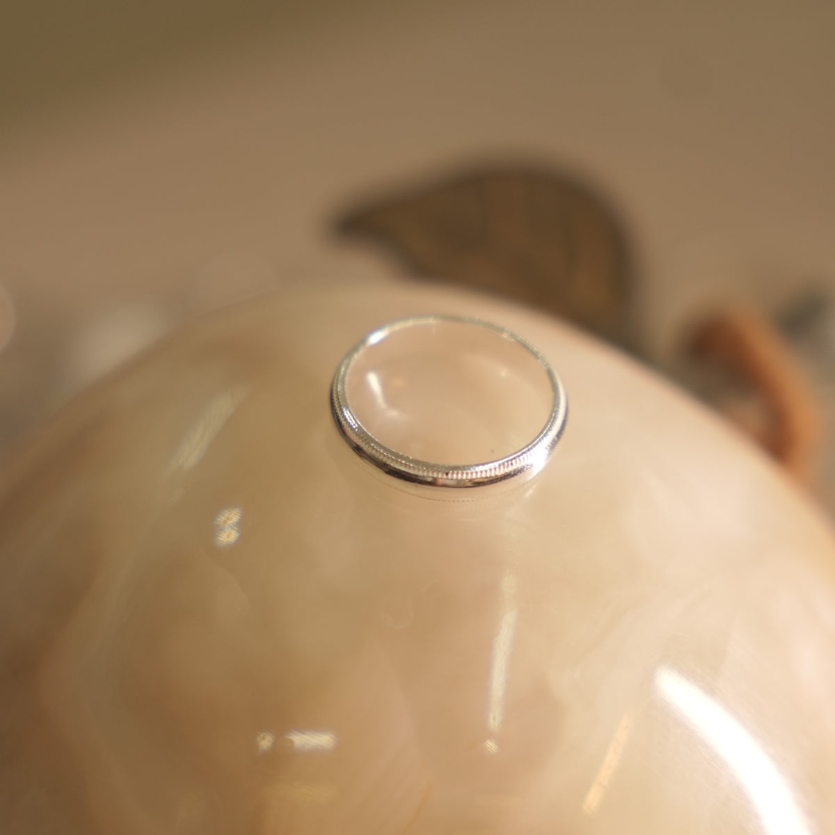 Angled view of the milgrain edge silver band, showing the rounded profile and beaded borders.