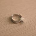 The screw motif spinner ring lying flat, showing the fixed rails either side of the rotating band.