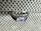 Front view of the sterling silver ring, showing the oval cubic zirconia held between two half-bezel shoulders.