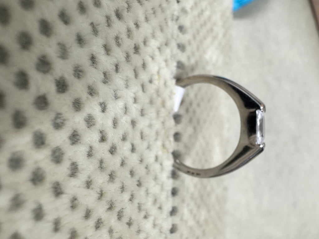 Profile of the sterling silver ring against textured fabric, showing the cathedral rise of the shoulders into the setting.
