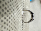 Profile of the sterling silver ring against textured fabric, showing the cathedral rise of the shoulders into the setting.