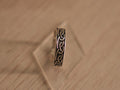 Oxidised sterling silver band ring carved with a continuous Viking style knot.