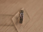 Oxidised sterling silver band ring carved with a continuous Viking style knot.