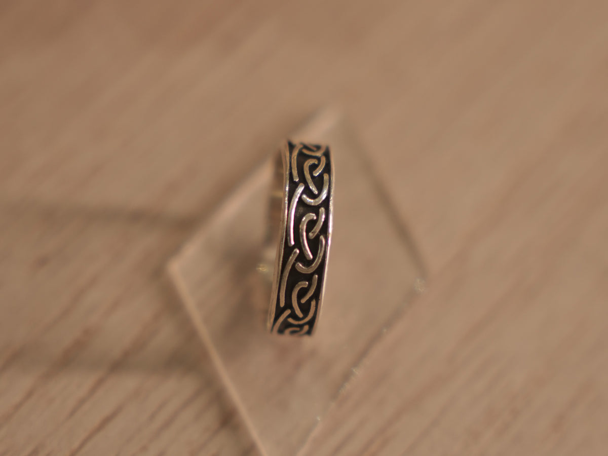 Oxidised sterling silver band ring carved with a continuous Viking style knot.