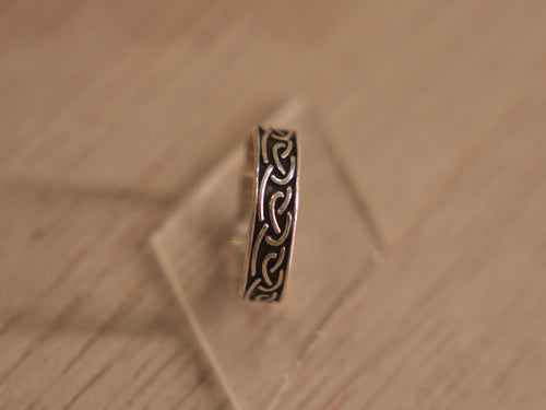 Oxidised sterling silver band ring carved with a continuous Viking style knot.