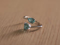 Sterling silver bypass ring with a sky blue pear shaped glass stone and a blue heart at the crossing.