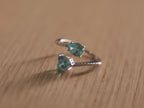Sterling silver bypass ring with a sky blue pear shaped glass stone and a blue heart at the crossing.