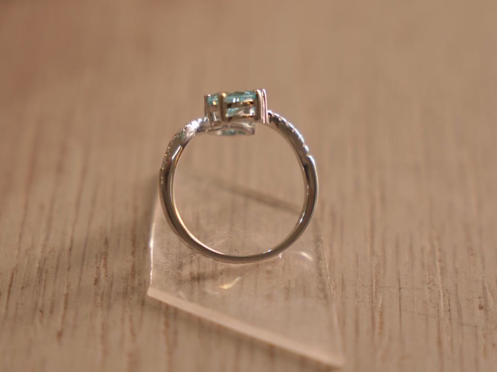 The sky blue stone bypass ring standing on its band.