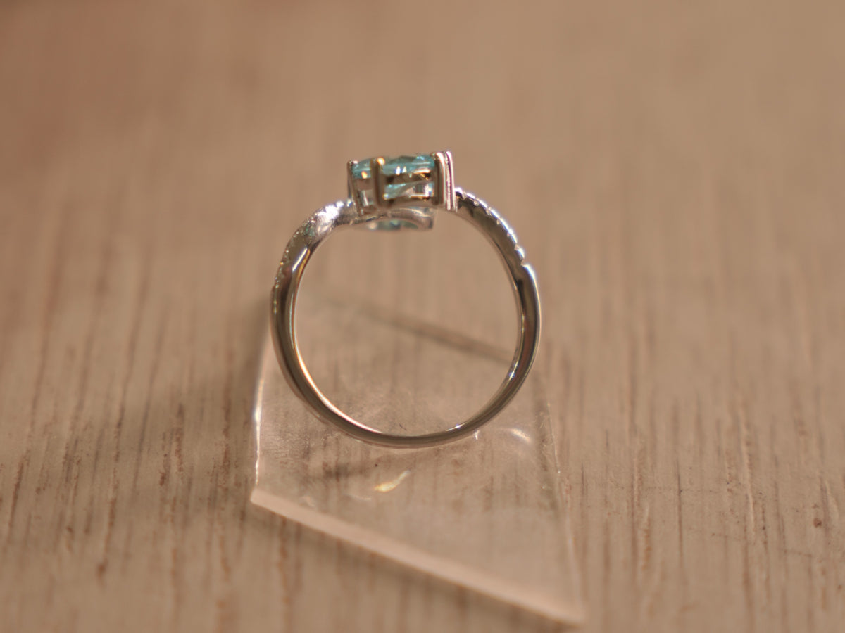 The sky blue stone bypass ring standing on its band.