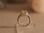 Sterling silver halo ring with a cushion cut vivid yellow glass stone in a four prong setting.