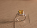 Close view of the yellow glass stone and colourless halo above the faceted band.