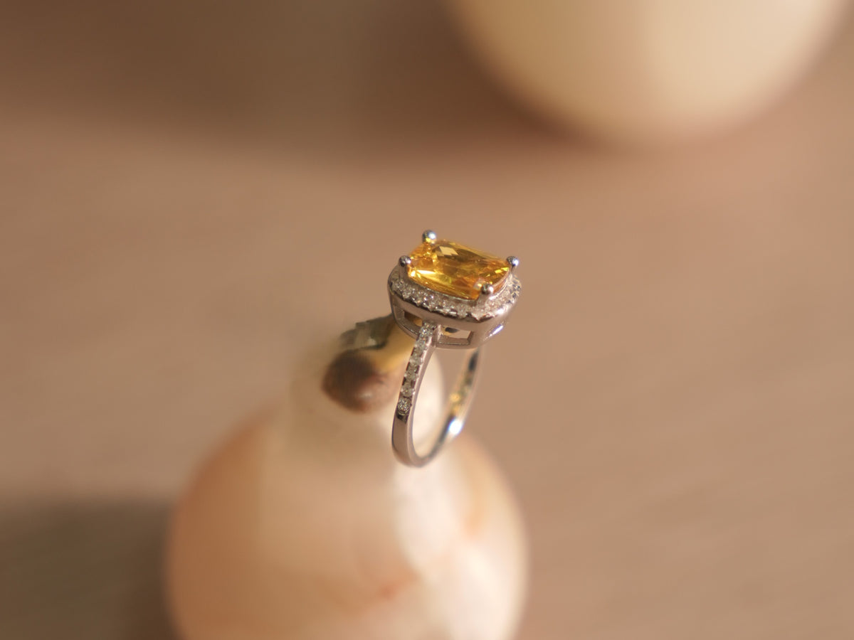 The yellow stone halo ring standing upright, showing the open basket under the stone.