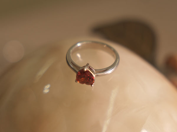 Sterling silver ring with a deep red heart shaped American Diamond on a plain polished band.