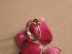 Close view of the deep red heart American Diamond in its prong setting.
