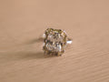 Sterling silver cocktail ring with a large colourless crystal centre framed by pale yellow and green stones.