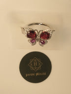 Front view of the butterfly ring standing above a Javeri House seal.