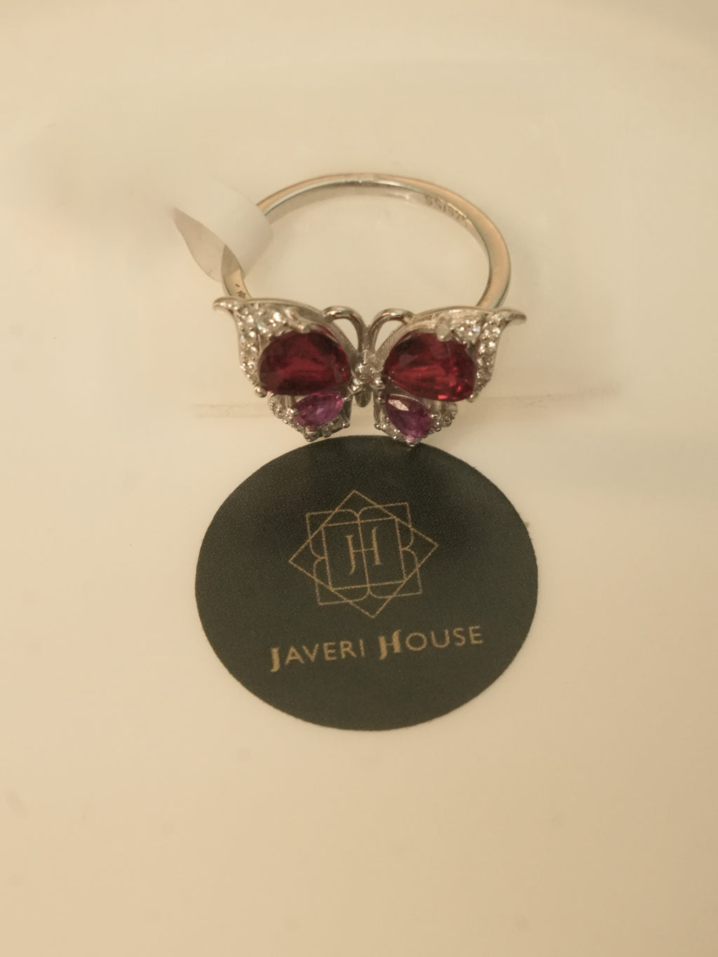 The butterfly ring seen at an angle, showing the band and the setting behind the wings.
