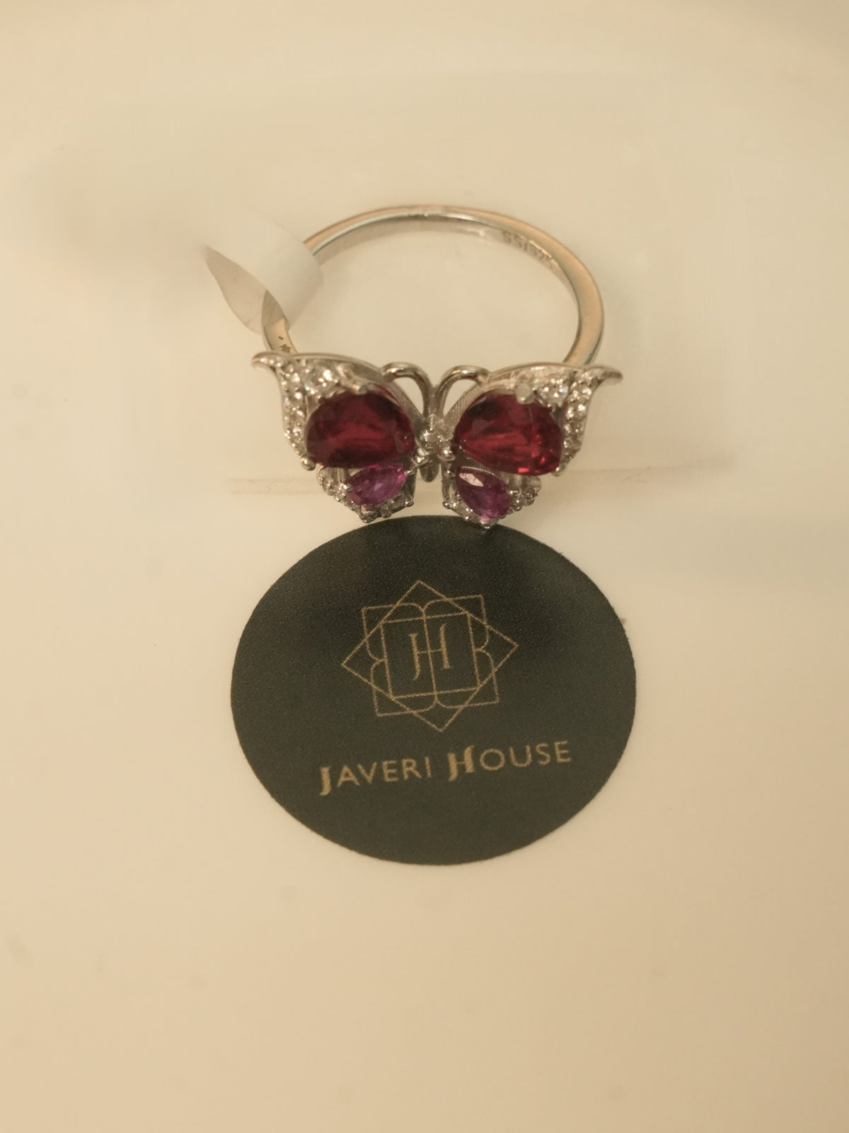 The butterfly ring seen at an angle, showing the band and the setting behind the wings.