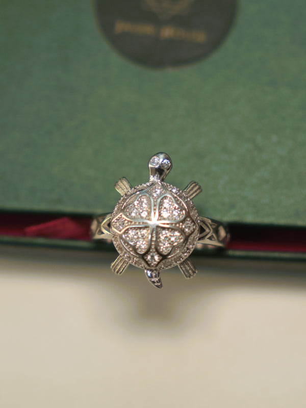 Top view of the tortoise ring, showing the four pave set petals and the stone set eyes.