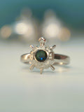 Front view of the octagon tortoise ring standing on a pale surface.