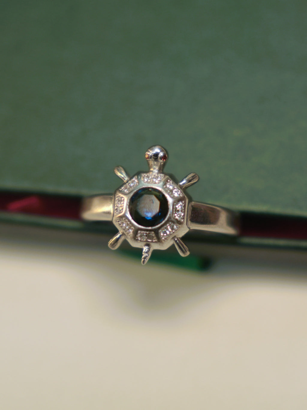 Top view of the octagon tortoise ring, showing the stone set panels around the blue centre.