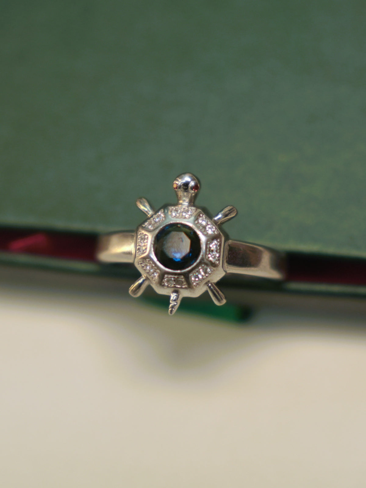 Top view of the octagon tortoise ring, showing the stone set panels around the blue centre.